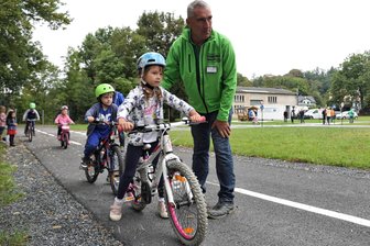 Neuer Verkehrsübungsplatz für Kinder: Wo Oelsnitz jetzt einen Kreisverkehr hat - Uwe Huster leitet die Kinder der Kita am Stadion auf dem neuen Verkehrsübungsplatz an.