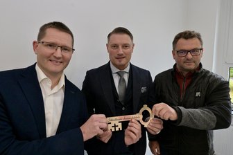 Neues Ärztehaus im Erzgebirge: Mediziner bekommt von Gemeinde den Schlüssel - Planer Torsten Leistner hat den symbolischen Schlüssel für die neue Arztpraxis in Schönheide an den Bürgermeister des Ortes, Thomas Lang, und den Nutzer, Dr. Jochen Wendler (von rechts), übergeben.
