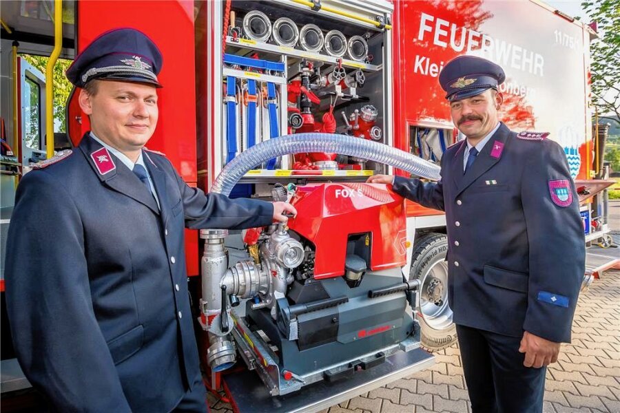 Neues Einsatzfahrzeug für die Feuerwehr Kleinneuschönberg - Wehrleiter Enrico Böttger (l.) und sein Stellvertreter Nils Reichelt an der Tragkraftspritze des GW-L2.