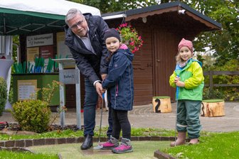 Neues Familienabenteuer im Erzgebirge zwischen Kät und Weihnachtspyramide - Sorina (6) und Marlene (4) beim ersten Abschlag, assistiert von Oberbürgermeister Rolf Schmidt.