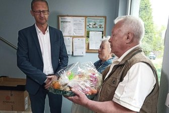 Neues Zuhause für Ukrainer - Tatjana und Leonid Lapin werden im Flur vom Geschäftsführer der Gebäudegesellschaft Limbach-Oberfrohna, Norbert Gruss, zum Einzug in ihre neue Wohnung mit einem Obstkorb begrüßt.