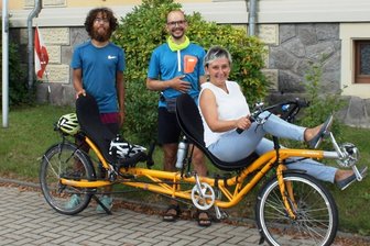 Neukirchen-Tour führt auch an die Pleiße - Tilman Jiménez Reichow (l.) und Malte Boßert bei ihrem Zwischenstopp in Neukirchen. Bürgermeisterin Ines Liebald macht auch auf dem Liegerad-Tandem eine gute Figur.