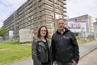Neun Millionen Euro für DDR-Plattenbau im Erzgebirge: Alter Wohnraum neu gedacht - Nicole Amft und Timo Korb, die Vorstände der Wohnungsbaugenossenschaft Oelsnitz, vor dem im Umbau befindlichen Plattenbau in Lugau.