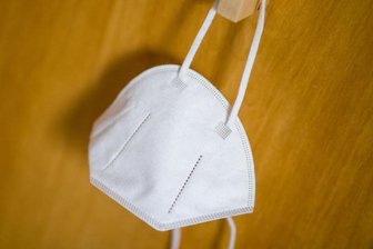 Eine FFP2-Maske hängt an einem Haken. (Archivbild).