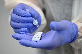 Ein Helfer verarbeitet eine Probe für einen Corona-Schnelltest im Staatlichen Berufsbildenden Schulzentrum Hildburghausen.