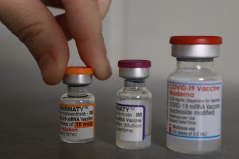 Newsblog Corona: Impf-Panne - Kinder bekommen Moderna statt Biontech - Flaschen mit den Impfstoffen Comirnaty und Moderna stehen in einem Impfstofflage, links der Impfstoff für Kinder von Biontech/Pfizer.