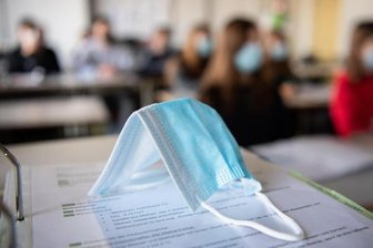            Eine Maske liegt auf einem Tisch in einer Münchner Schule.