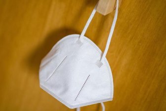 Eine FFP2-Maske hängt an einem Haken. (Archivbild).