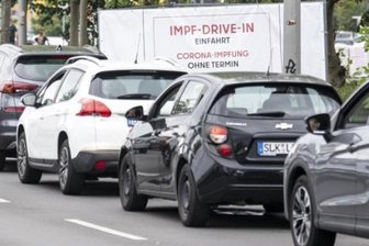 Newsblog Corona: Sieben-Tage-Inzidenz springt auf zweistelligen Wert - Eine lange Schlange bildet sich vor der Einfahrt zur Impfung an der Ikea-Filiale Lichtenberg vor dem Schild mit der Aufschrift "Impf-Drive-In Einfahrt Corona-Impfung Ohne Termin". 