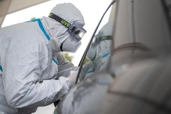Ein Mitarbeiter der Corona-Abstrichstelle Heilbronn führt einen Coronatest durch.