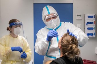 Newsblog Coronavirus - die aktuelle Entwicklung - Eine Reiserückkehrerin (r) lässt sich in einer Covid-19-Teststation am Hauptbahnhof in Stuttgart testen.