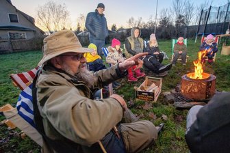 Nichts für Stubenhocker: Wie Kinder in Plauen raus in die Natur gelockt werden - Die Straßberger Wölfe sind eine abenteuerlustige Gruppe von Kindern. Diese treffen sich immer mittwochs - oft auch am Lagerfeuer im Straßberger Pfarrgarten und hören Dietrich Moosdorf (links) zu.