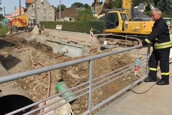 Niederdorfer Feuerwehrchef kritisiert Baumaßnahme - Gemeindewehrleiter Jürgen Pfüller schaut auf das Baustellenproblem: Bei plötzlichem Starkregen können die Erdmassen im derzeit trockengelegten Gablenzflussbett wie eine Mauer wirken. Es drohen Überschwemmungen für die angrenzenden Grundstücke. Links das Rohr, in welchem das Wasser hinab Richtung Chemnitz geleitet wird.
