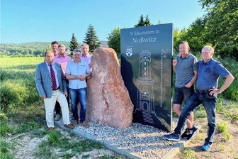 Noßwitz grüßt jetzt mit Wahrzeichen des Rochlitzer Berges seine Gäste - Wilfried Hänchen (v. l.), Nicky Dreihaupt, Heiko Dost, Mike Speer, OB Frank Dehne, Silvio Weißhuhn und Frank Weber vor einem der neuen Begrüßungstafeln in Noßwitz.