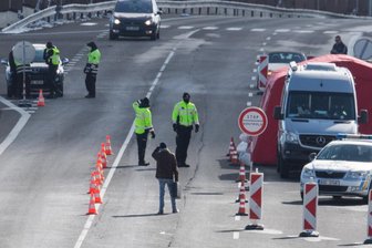 Nun sind in Tschechien auch die Gaststätten zu - Tschechische Polizisten stehen am Samstag zur Einreisekontrolle auf einer Straße in Zinnwald an der tschechischen Grenze.
