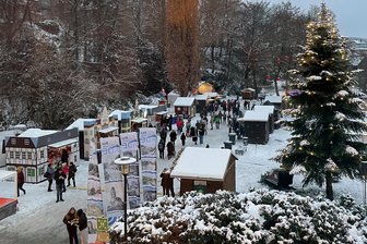 Nur ein Wochenende: Ist der Weihnachtsmarkt in Aue zu kurz? - Der Blick von oben auf einen Teil des verschneiten Weihnachtsmarktes in Aue. Dieses Jahr gab es auch Programmpunkte und Verkaufsstände im angrenzenden Kulturhaus und dessen Innenhof.