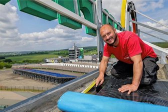 Nur noch wenige Tage bis zum MotoGP: Das muss man jetzt zum Sachsenring wissen - Den wohl höchsten Arbeitsplatz an der Rennstrecke hat zurzeit Dachdecker Didier Grams auf dem ADAC-Turm. Der Limbach-Oberfrohnaer ist selbst Rennfahrer, nennt den Sachsenring seine Lieblingsrennstrecke. 