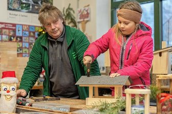Oberlauterbacher Hofweihnacht lockt mit Handwerkermarkt, Backen und Führungen Gäste an - Michelle deckt in der Holzwerkstatt unter der sachkundigen Anleitung von Andreas Borowski das Daches eines Futterhauses mit Dachpappe.