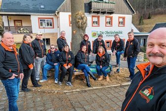 Oberlochmühle: Wo 60 Prozent der Einwohner einem Verein angehören - Frank Gude (r.) steht dem Verein seit dessen Gründung vor. Als nächstes Projekt soll ein Baumstumpf (Hintergrund Mitte), der sich an dem vom Verein gebauten Wanderparkplatz befindet, durch einen Kettensägenschnitzer in eine Skulptur verwandelt werden. Über das Motiv beraten die Vereinsmitglieder derzeit noch. 