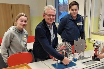 Oberschule Lichtentanne mit Plakette und Preisgeld gewürdigt - Hanna, Schulleiter Uwe Wappert, der auch Physik unterrichtet, Emanuel und Jakob (v.l.) präsentieren den Besuchern des Fachkabinetts ein elektrostatisches Glockenspiel. 