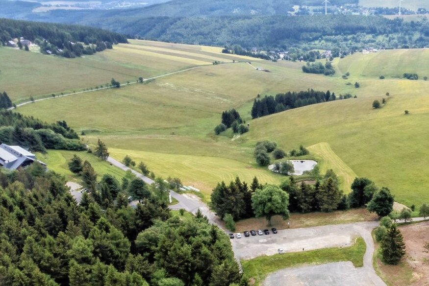 Oberwiesenthal: Naturschützer wollen Ferienhaus-Projekt am Fichtelberg stoppen - Oberhalb der Teiche und direkt unterhalb der Emil-Riedel-Straße sollen die Ferienhäuser entstehen. Ganz links ist das Hotel von Jens Weißflog zu sehen, vorn der Parkplatz "Rotes Vorwerk". 