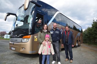 Oberwürschnitzer Busbetrieb Fröhlich: Die nächste Generation übernimmt das Steuer - Ein Busbetrieb als Familienunternehmen: Thomas Fröhlich (rechts) übergibt die Firma an Sohn Toni Fröhlich (Zweiter von rechts). Günter Fröhlich (im Bus) hat das Unternehmen gegründet. Tonis Partnerin Claudia Glaß und Tochter Johanna, die vierte Generation, ziehen ebenfalls mit.