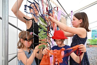 Oederan: Ein Tausendfüßler krabbelt durchs „Alle-Welt-Zelt“ - Weben am Bauzaun: Lore, Elisabeth, Johanna und Mona (v. l.) erschaffen einen Tausendfüßler.