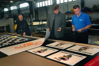 Oelsnitzer Teppichhersteller Halbmond gibt Gummi - Mit Gummi beschichtete Matten sind ein neues Standbein des Oelsnitzer Teppichherstellers Halbmond: Uwe Ernstberger, Geschäftsführer Ralf Litzenberg und Besic Sahbaz (von links) in der Produktion der Tochterfirma Jobet in der renovierten Halle 7 - ehemals Fabrikverkauf des Unternehmens.