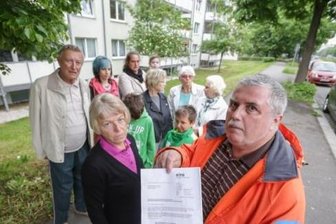 Offene Rechnungen beim Versorger: Trinkwasser-Sperre abgewendet - Marita und Steffen Wünsch (vorn) und andere Mieter der Häuser Carl-von-Ossietzky-Straße 107, 109 und 111 mit dem Aushang, in dem ihnen der Versorger Eins die Einstellung der Trinkwasserlieferung und das Abschalten des Stroms für das Hauslicht für kommenden Montag ankündigt hatte.