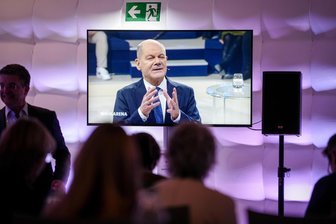 Olaf Scholz – ein beinharter Verhandler und normaler Mensch - Bundeskanzler Olaf Scholz (SPD) ist auf einem Bildschirm während der ARD-Sendung „Wahlarena“ zu sehen.