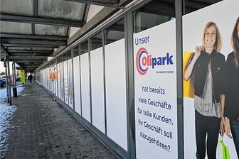 Olipark: Bäckerei schließt, Pop Up öffnet - Statt einladender Schaufenster sind viele Läden nur mit Werbung geschmückt, weil es dahinter keine Angebote gibt. Der Leerstand nimmt zu. 