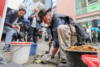 Opernchor gedenkt früherem Direktor mit Stolperstein - Künstler Gunter Demnig hat am Dienstag den ersten von 23 Stolpersteinen in der Börnichsgasse verlegt. Im Hintergrund steht der Opernchor. Seine Mitglieder hatten angeregt, dass damit an Leon Jessel erinnert wird. 