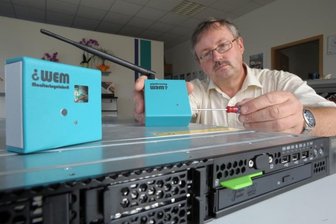 Ottendorfer Computerfirma PTS entwickelt Bauteil mit großer Wirkung - PTS-Geschäftsführer Lutz Scheibe zeigt die Erfindung aus Ottendorf: Der Sensor bzw. das Messgerät (links oben) signalisieren, wenn ein Computer (unten) beispielsweise zu heiß wird. Das Signal trifft auf den Empfänger (rechts oben), der wiederum per SMS aufs Handy die Information weitergibt.