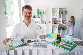 Parken, Toiletten, Highlights: Was Besucher zum Fest 100 Jahre Stadtrecht Oelsnitz wissen müssen - Beim Anliegen rund ums Fest wird am Wochenende in der Kammerrat-Beck-Straße 9 in Oelsnitz ein Anlaufpunkt der Stadt zu finden sein. Auch Mitbringsel gibt es dort. Felix Weigel, Auszubildender zum Verwaltungsfachangestellten, sowie Antje Lohse, Fachbereichsleiterin Finanzen und Hauptverwaltung, halfen am Dienstag bei den Vorbereitungen.