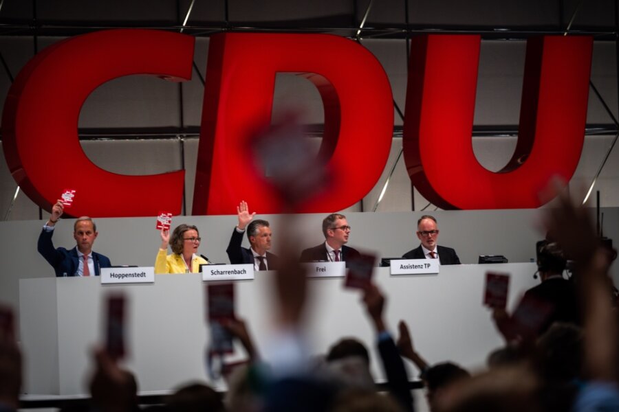Parteitag in Hannover: CDU stimmt für schrittweise Frauenquote - Delegierte halten beim CDU Bundesparteitag ihre Stimmkarte hoch. Der 35. Parteitag der CDU auf dem Messegelände wird seit der Corona-Pandemie erstmals wieder in Präsenz abgehalten.