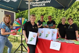 Peter-Maffay-Stiftung: Grüner Drache Tabaluga im Erzgebirge - Marina Reller, Uta Riedel (v. l.) und weitere Helfer am Stand der Peter-Maffay-Stiftung.