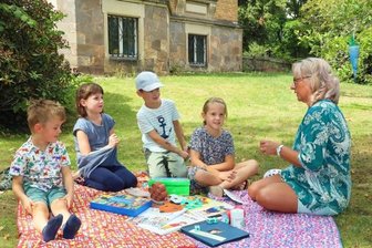 Petition gegen Sparkurs bei Sprach-Kitas - Sprach-Fachkraft Gabriele Bluhm mit Clara, Tim, Paula und Fidel in der "Philosophier-Runde" im Garten der "Sterntaler".