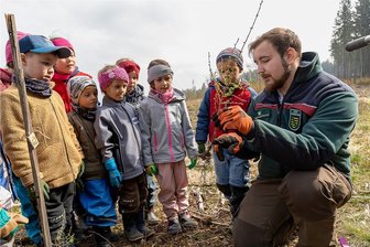 Pflanzaktion am Steinberg - Im Bild erklärt Forstinspektor-Anwärter Sören Sponholz von Sachsenforst Plauen den "Großen" aus der Kita Wildenauer Strolche, was sie beim Pflanzen des Lärchen-Setzlings beachten müssen. 