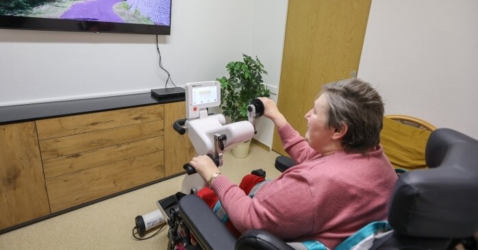 Pflege aus Sicht des Gepflegten gedacht - Eine ältere Frau trainiert am Motomed, einem Sportgerät speziell für Senioren, das die Pflegeeinrichtung gekauft hat.