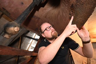 Philipp Kahlerts Traum von neuen Kirchenglocken für Wilkau-Haßlau - Philipp Kahlert, Mitglied im Kirchenvorstand, zeigt auf eine Schadstelle an der großen Glocke.