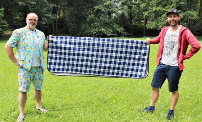 Picknick und mehr im Baumwollpark - Manuel Grießbach (rechts), der Chef des Gewerbe- und Festvereins Flöha, sowie Vereinsmitglied Daniel Ivandic haben schon einmal zur Probe eine Picknickdecke im Baumwollpark ausgebreitet. 