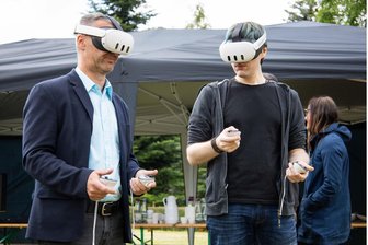 Pilotprojekt im Vogtland: Großvermieter will neues Gebäude mit Künstlicher Intelligenz entwerfen - Rico Schmidt, Aufsichtsratsvorsitzender der Wohnungsgesellschaft Adorf, ließ sich von Architekt Marc Zahradnik die verschiedenen KI-generierten-Bebauungsvarianten auf der Freifläche am Remtengrüner Weg im virtuellen Raum zeigen.