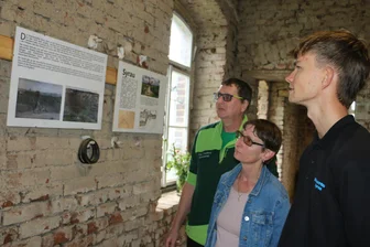 Pläne für den Syrauer Wasserturm locken viele Besucher an - Yannick Färber (rechts) zeigt Simone Podstawa und Stephan Müller die Ausstellung zur Historie des Wasserturmes.