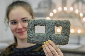 Plattenbau zum Anbeißen: Wie ein Keks Lust auf Chemnitz macht - Jessica Spranger, Mitarbeiterin in der Tourist-Information, zeigt eine "Chemnitzer Platte": ein Gebäck, das an ein Betonelement eines WBS-70-Wohnblocks erinnern soll.