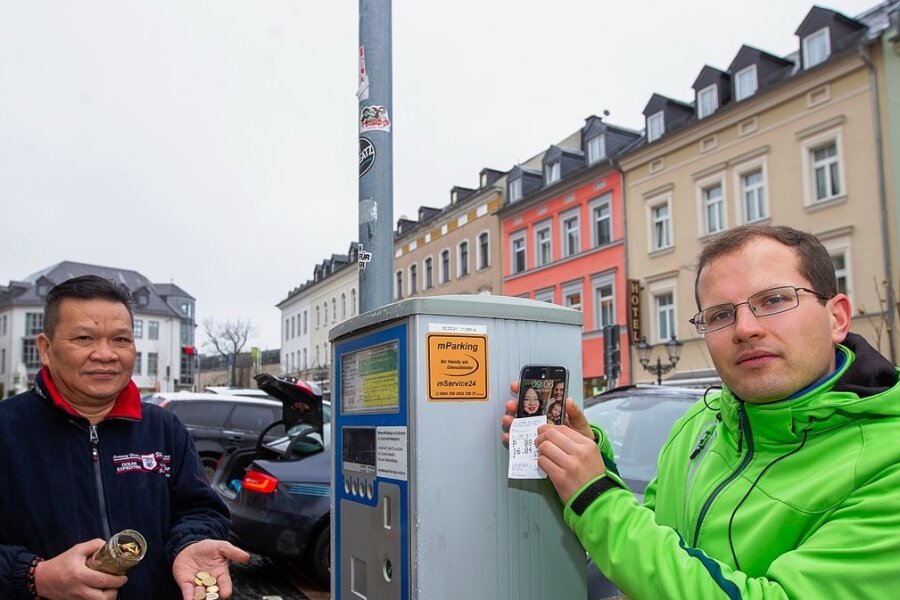 Plauen schafft Handy-Parken wieder ab - Auch wenn ein Aufkleber am Automaten noch für das digitale Parkticket wirbt: Seit April sind Maximilian Hahn und sein Schwiegervater Men Le Van auf dem Plauener Klostermarkt wieder auf Münzgeld angewiesen. 