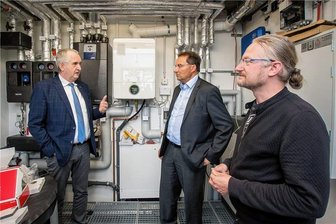 Pockau-Lengefeld wird vom Freistaat bei Investitionen in die Zukunft und in Historisches unterstützt - Staatsminister Thomas Schmidt,Bürgermeister Ingolf Wappler und Energiemanager Matthias Thümmel (v.l.) im Technikraum des Kinderhauses.