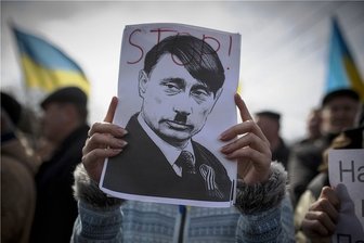 Politikwissenschaftler über Angst vor neuem Weltkrieg: "Putin ist kein zweiter Hitler" - Bereits vor acht Jahren zeigen Demonstranten in Simferopol, der Hauptstadt der Autonomen Republik Krim, ein Plakat, das den russischen Präsidenten Wladimir Putin als den deutschen Diktator Adolf Hitler porträtiert. 