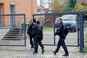 Polizei durchsucht mehrere Objekte in Chemnitz - Polizeibeamte betreten das Grundstück eines der durchsuchten Objekte an der Adelsbergstraße in Chemnitz.
