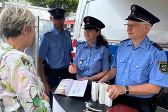 Polizei macht in Mittweida fit für Urlaub und Alltag: Sechs Tipps gegen Einbrecher und Diebe - Haben am Donnerstag auf Präventionstour der Polizeidirektion Chemnitz auf dem Mittweidaer Markt beraten (v.r.): Polizeihauptmeister Ingo Roscher, Polizeihauptmeisterin Kathy Seyferth und Polizeihauptmeister und Bürgerpolizist Marcel Grimmer.
