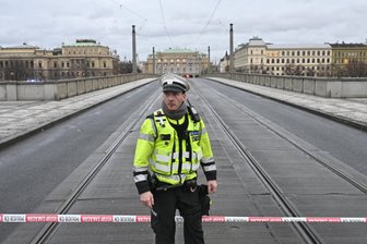 Ein Polizist steht auf der gesperrten Mánes-Brücke. An einer Hochschule in der Prager Innenstadt sollen Schüsse gefallen sein.